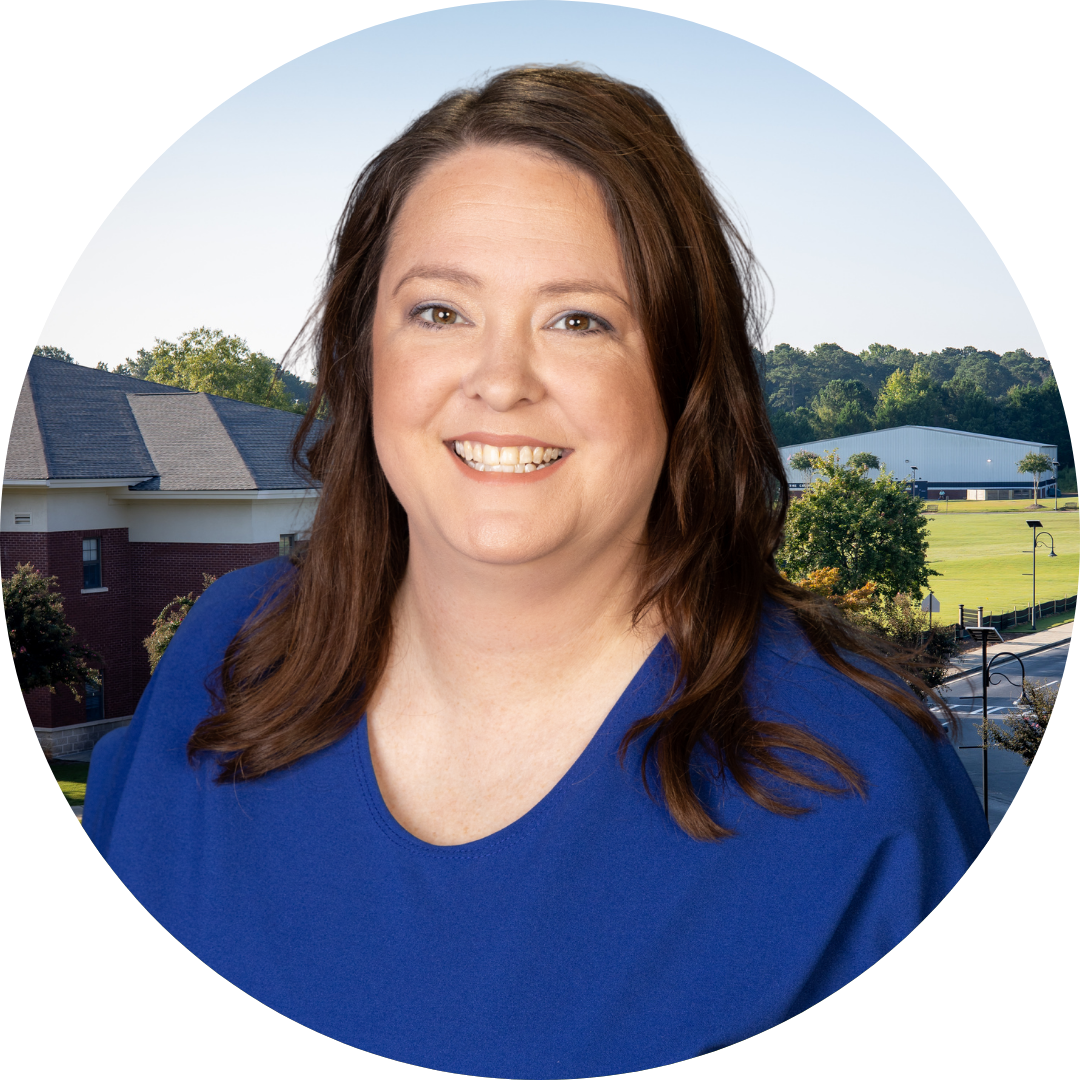A smiling woman in front of a school building