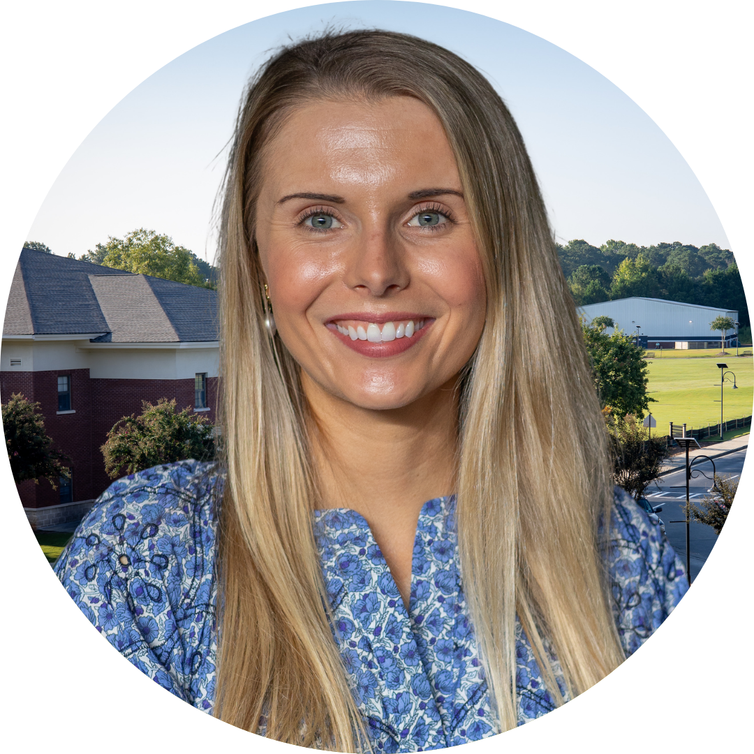 A smiling woman in front of a school building