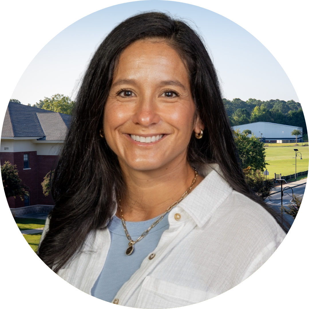 A smiling woman in front of a school building