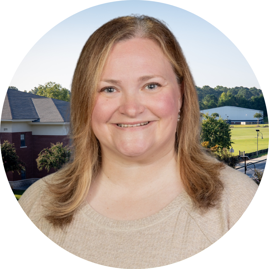 A smiling woman in front of a school building