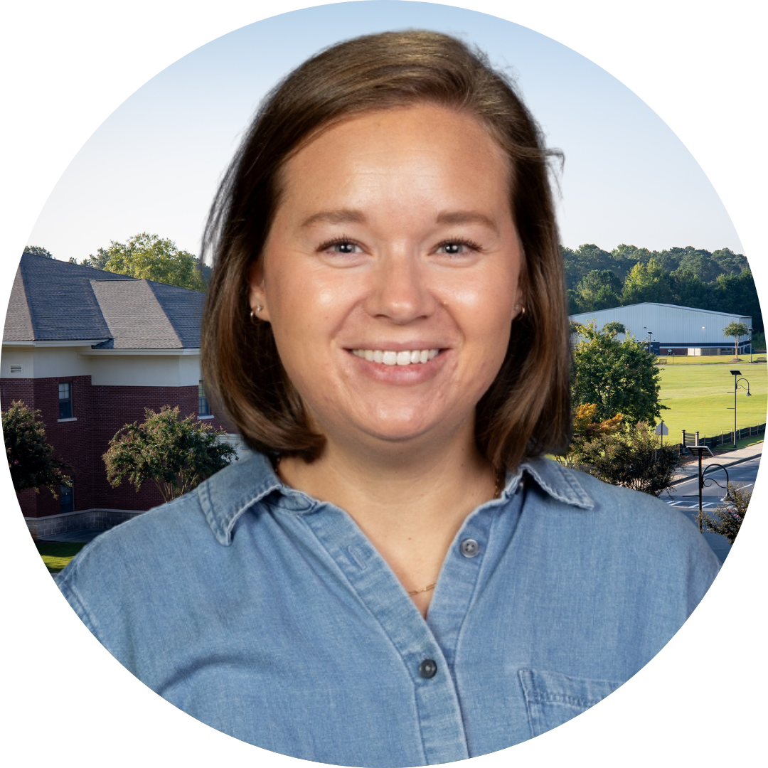 A smiling woman in front of a school building