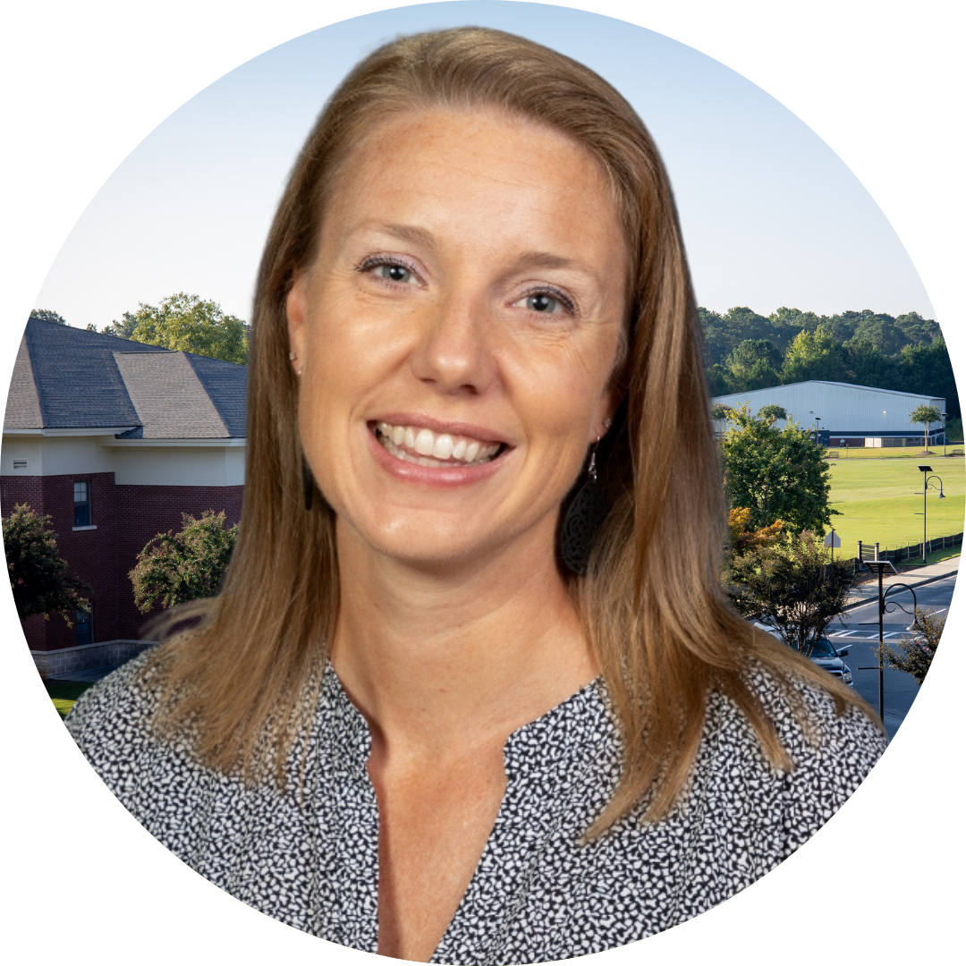 A smiling woman in front of a school building