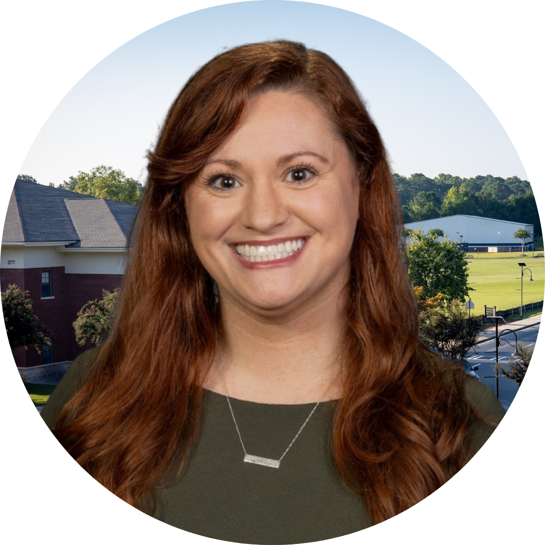 A smiling woman in front of a school building