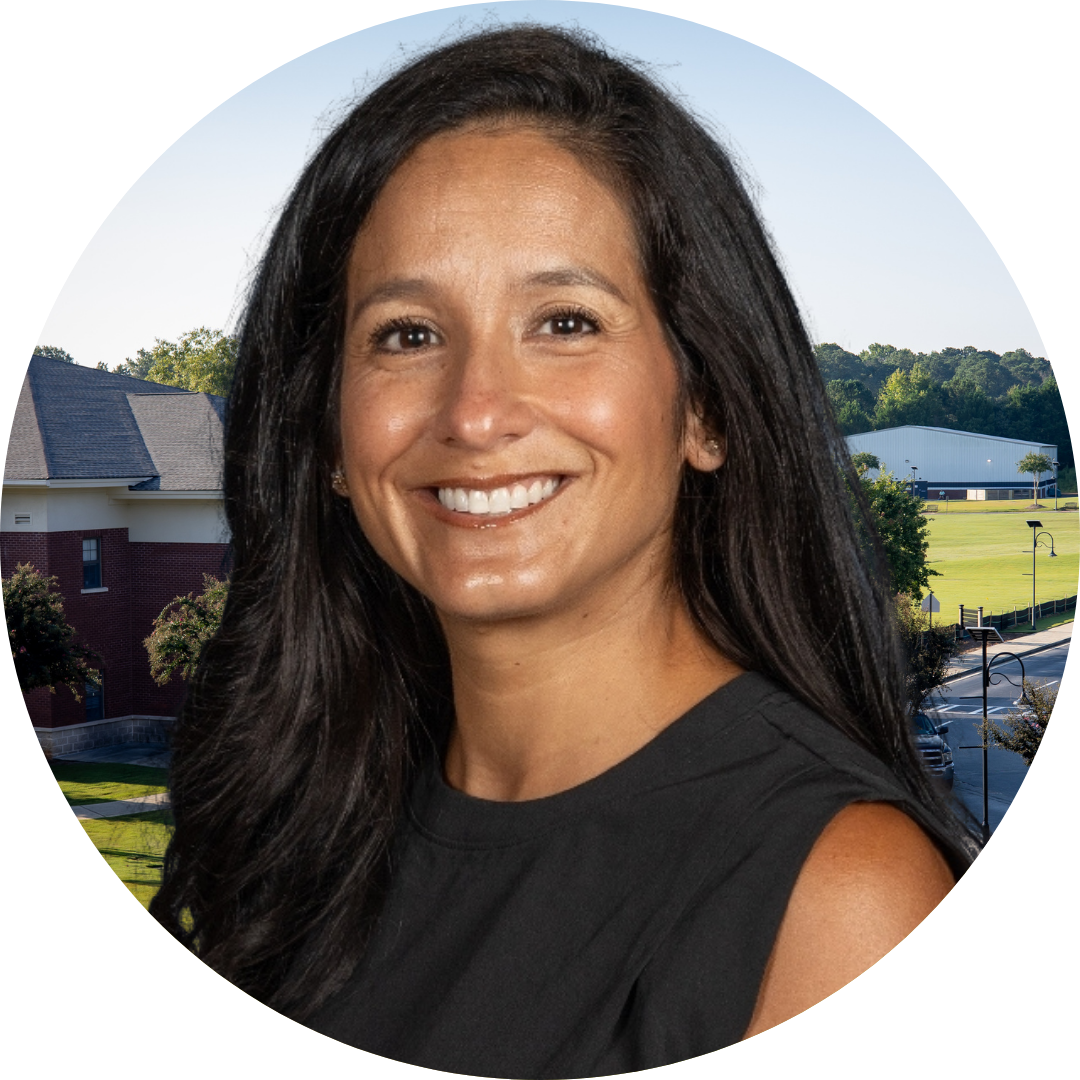 A smiling woman in front of a school building