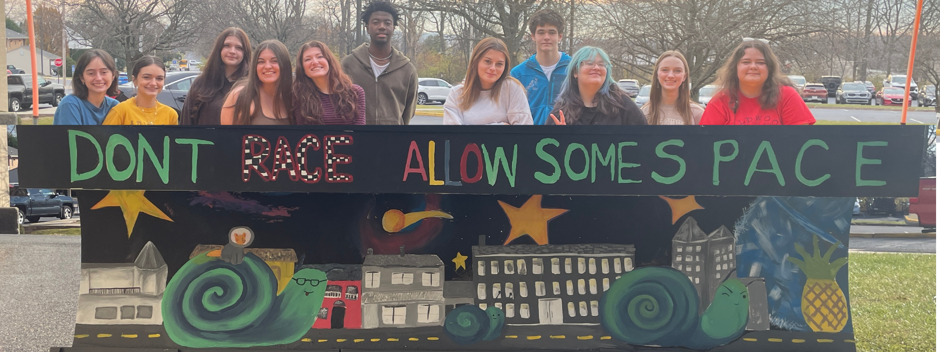 Students standing behind painted plow