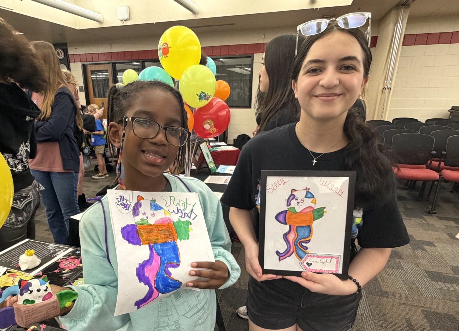 students showing off their artwork
