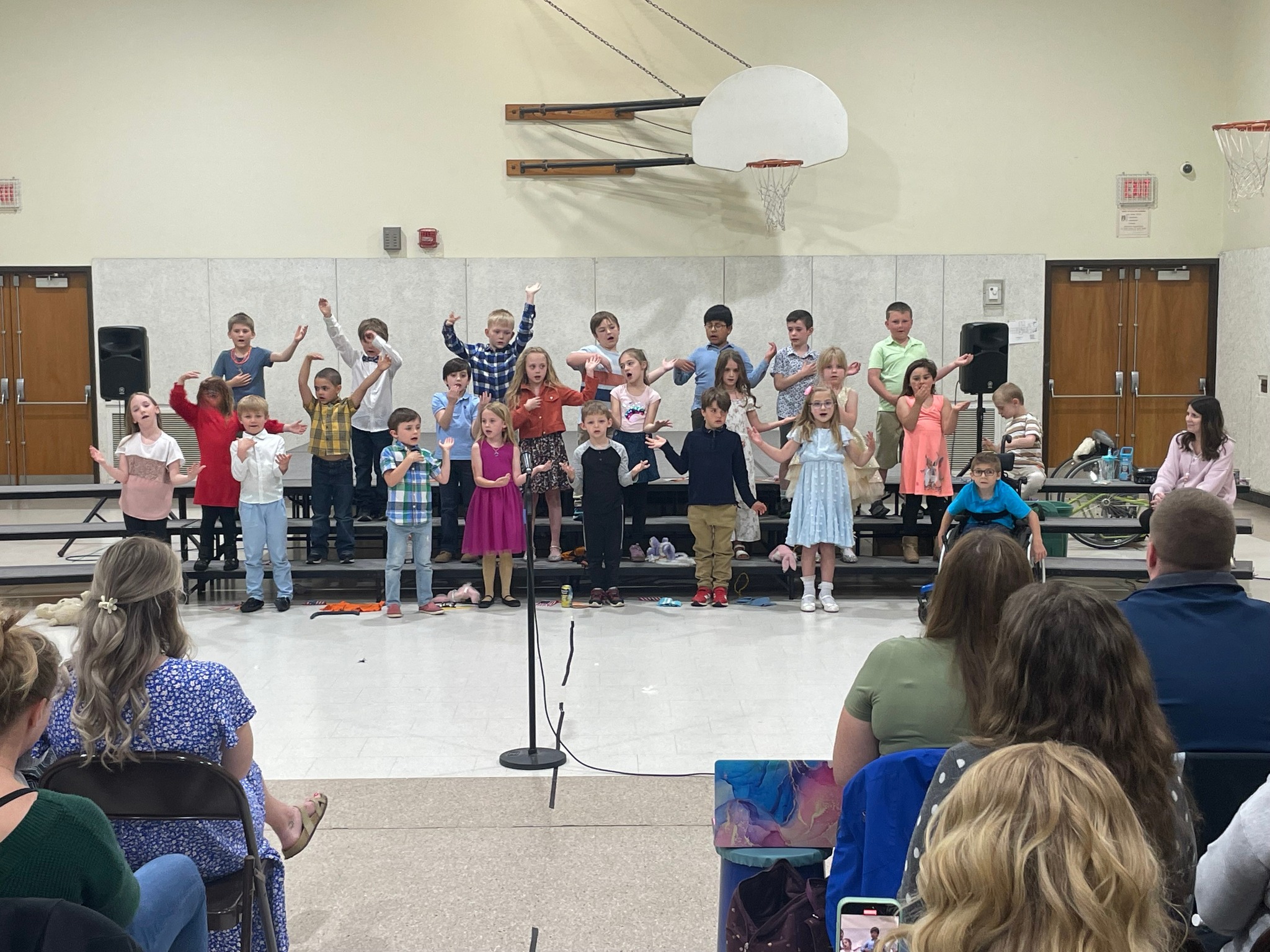 Image of first grade students on risers performing for parents.