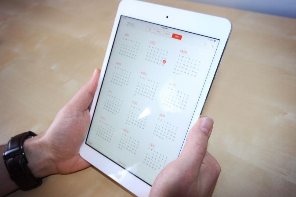 Person holding an iPad with a calendar app open