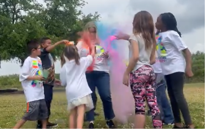 Mrs. Edgar being covered with color by students