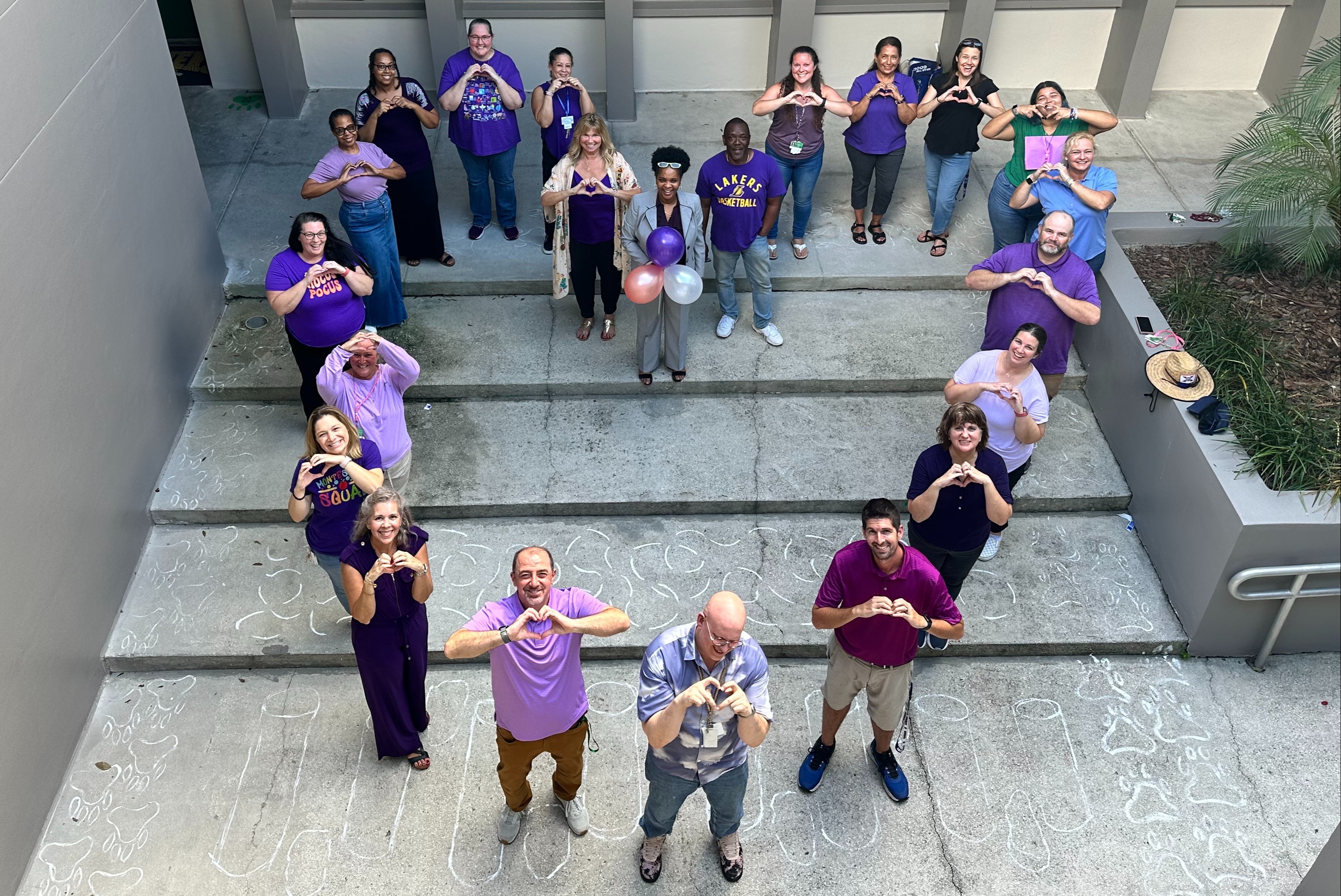 Staff standing together in the shape of a heart.