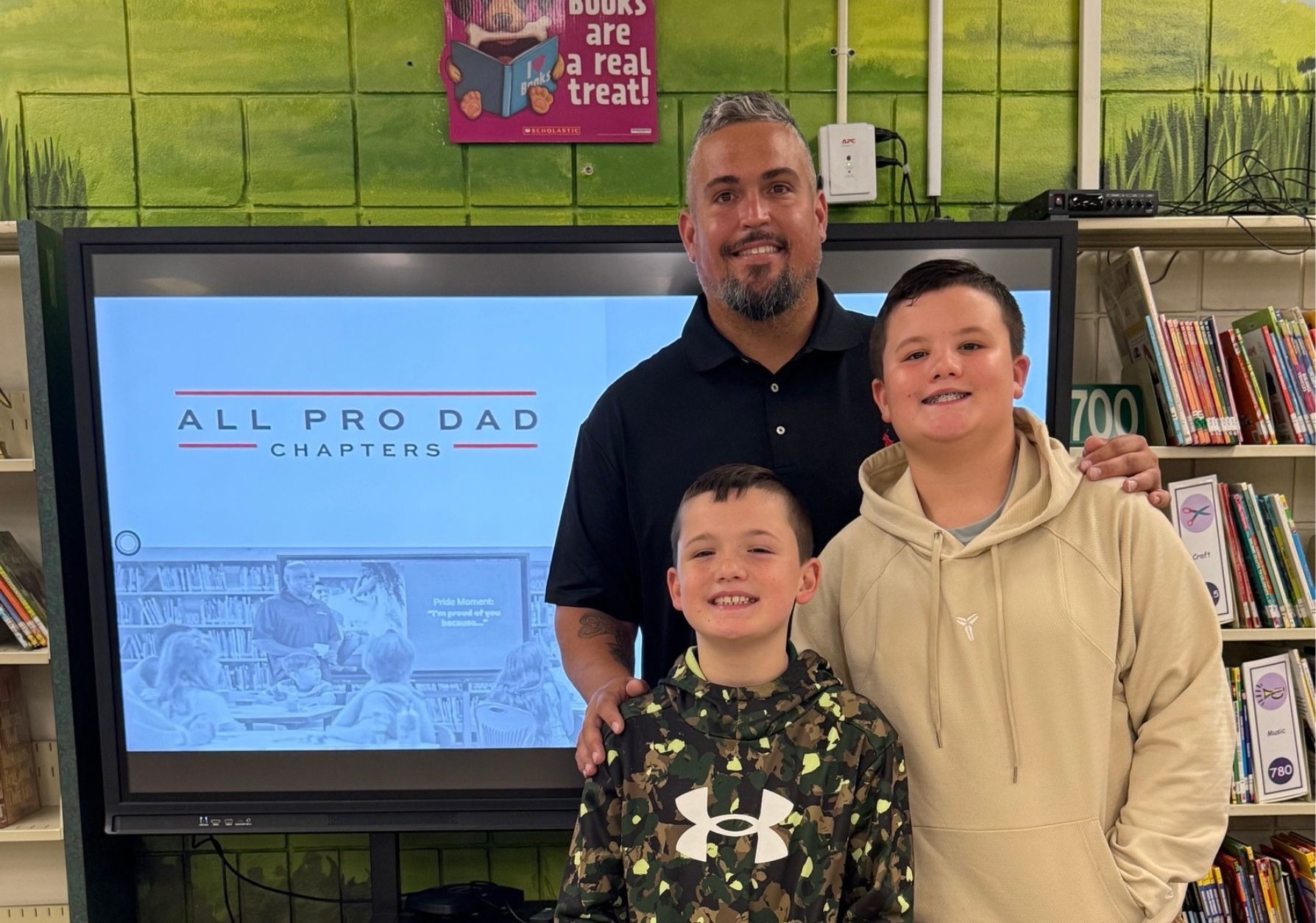 Father supporting sons at monthly All Pro Dads Meeting.