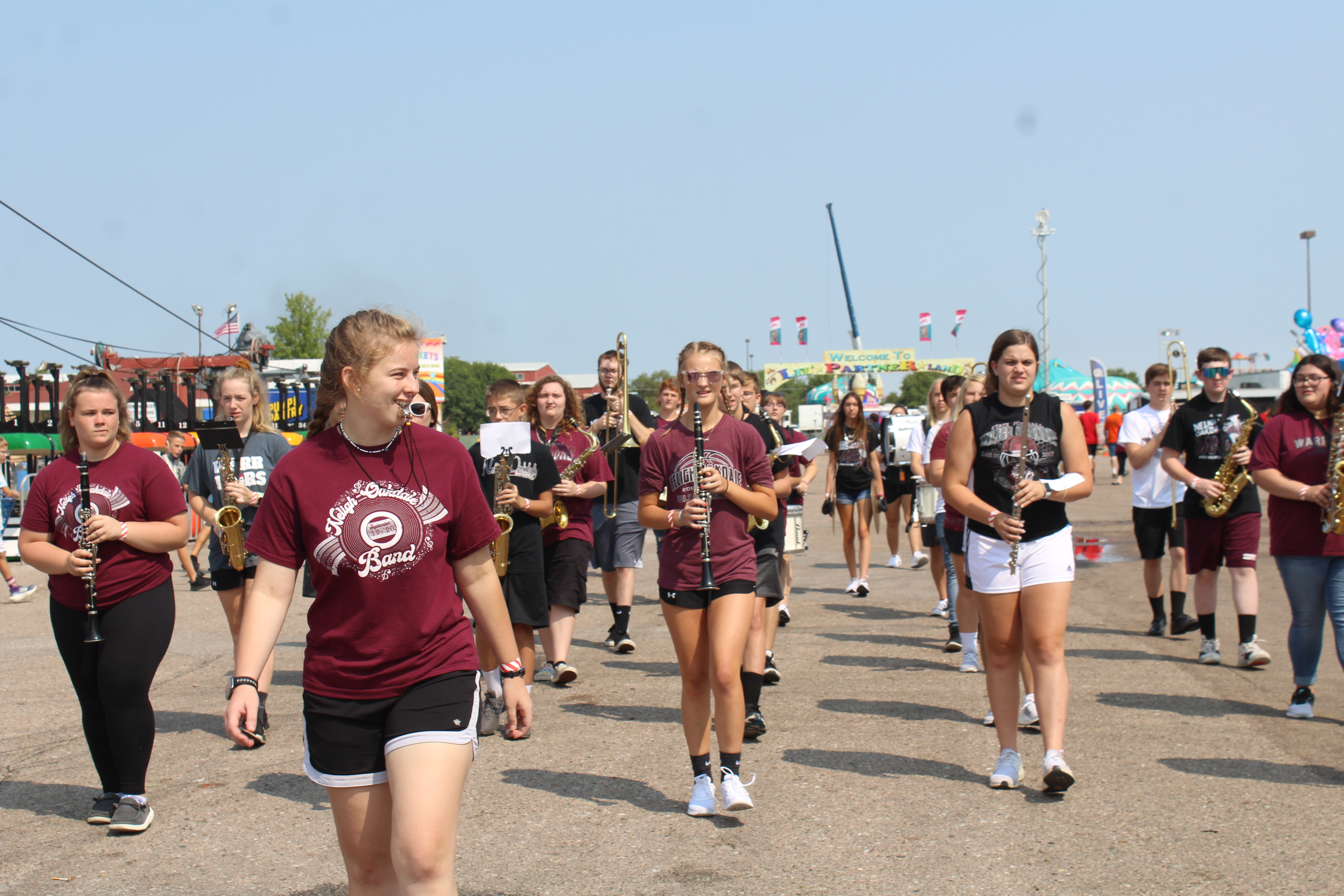 The band is getting ready to march past a crowd at the state fair.