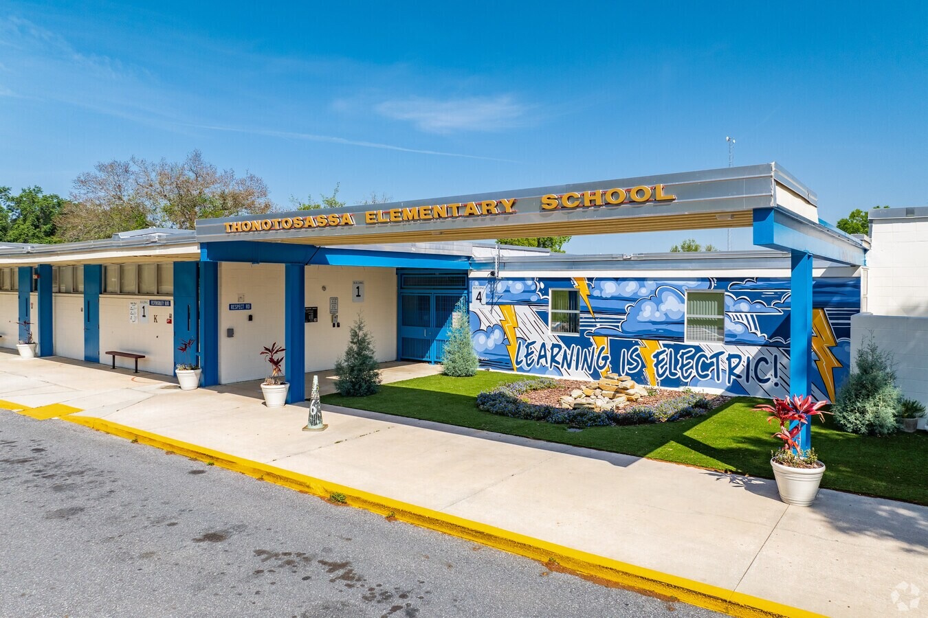 view of the front of  the school with a mural that says learning is electric