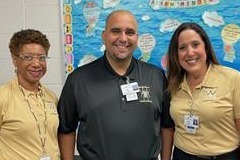 One male adult in between to female with the sale color of shirts all smiling