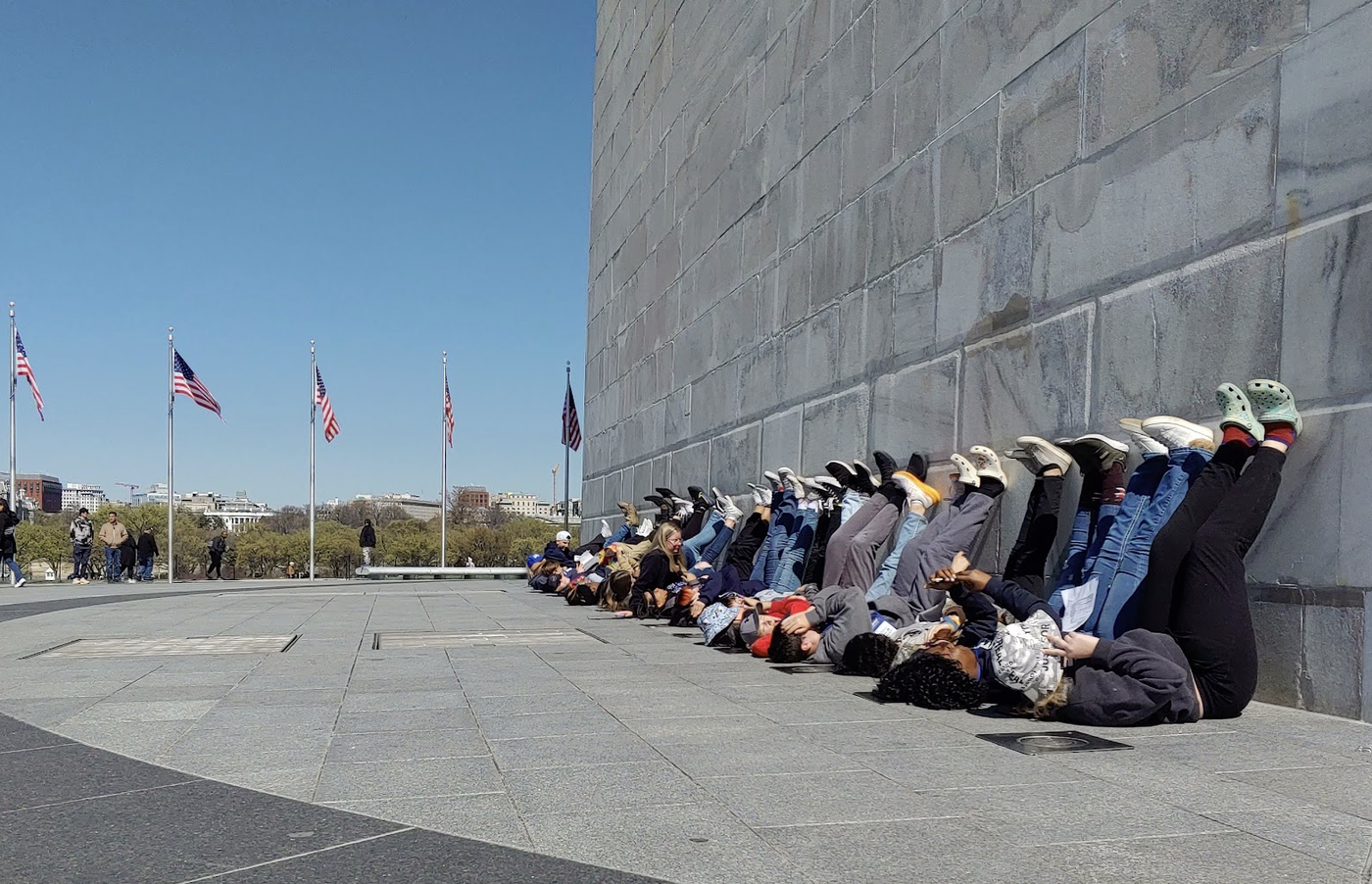 Students laying on their backs with their feet against the wall