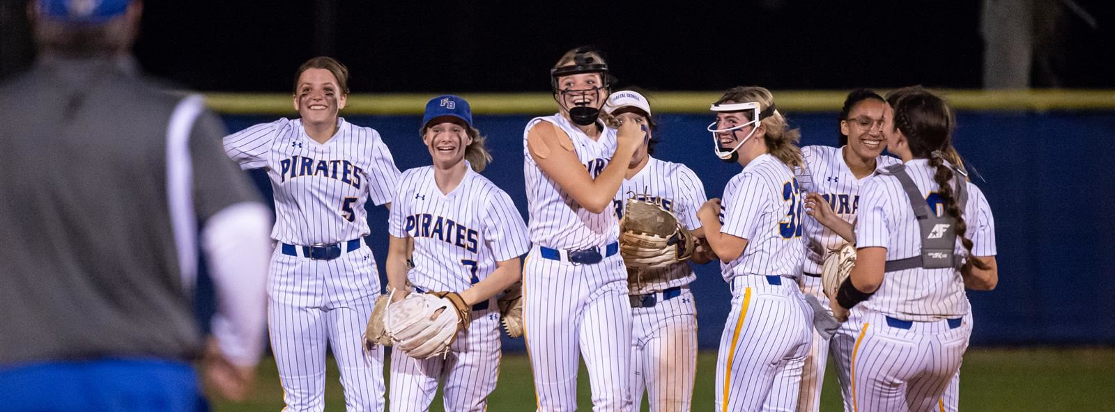 girls softball team gather on the pitchers mound
