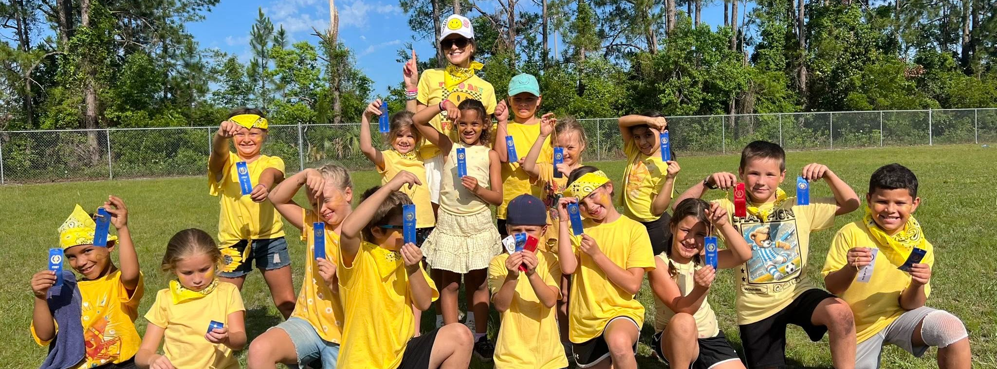 group of young students wearing all yellow posing outside with their ribbons