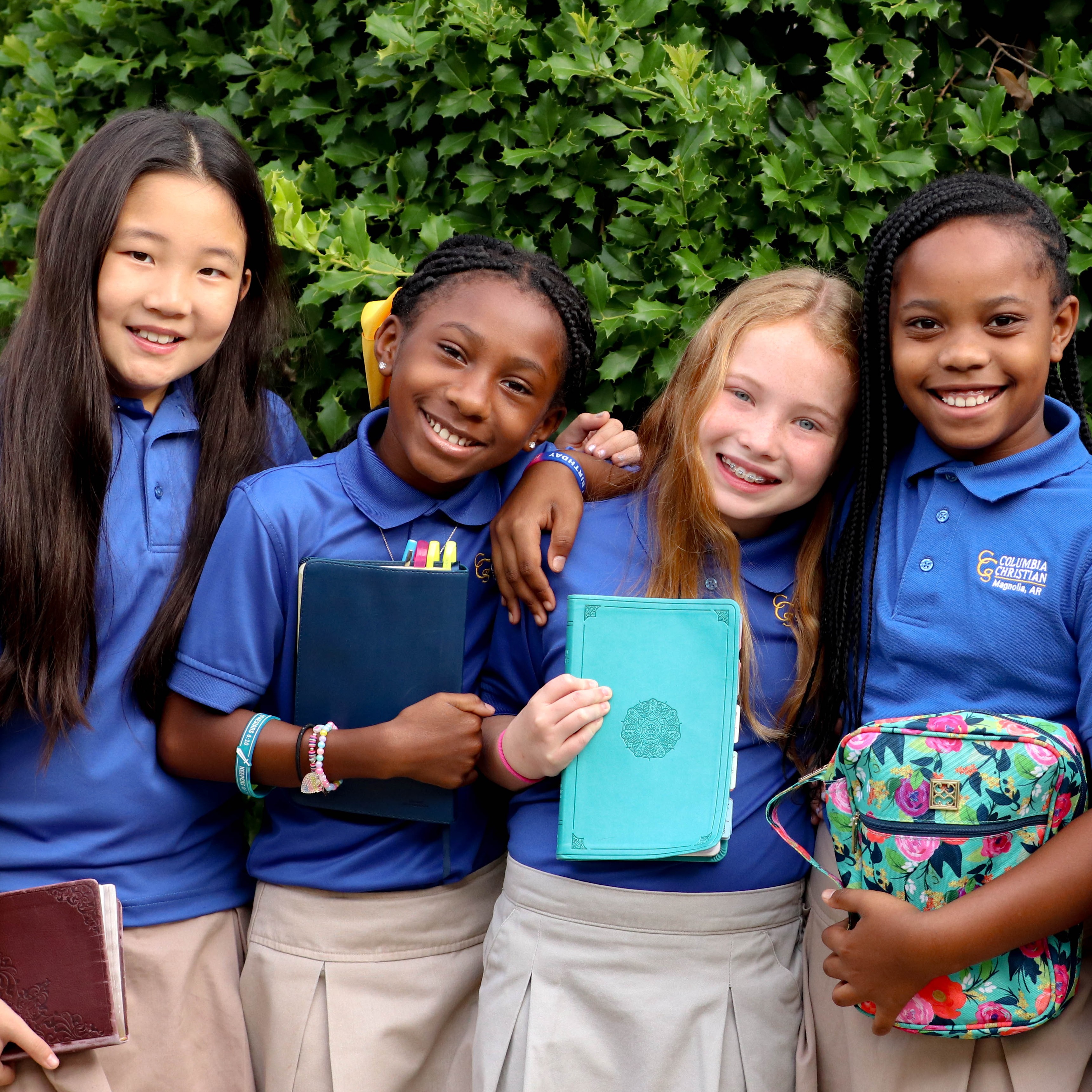 Columbia Christian students holding their Bibles, smiling at the camera.
