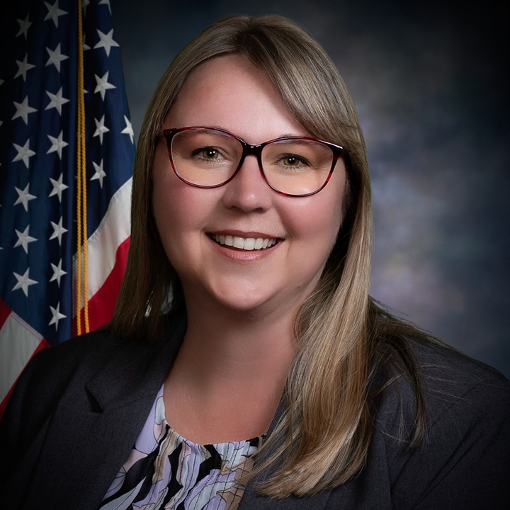 1. A smiling woman in glasses and a suit, exuding confidence and professionalism. 2. A woman wearing glasses and a suit smiles warmly, showcasing her approachable demeanor. 3. A confident woman in a suit and glasses smiles, reflecting professionalism and positivity.