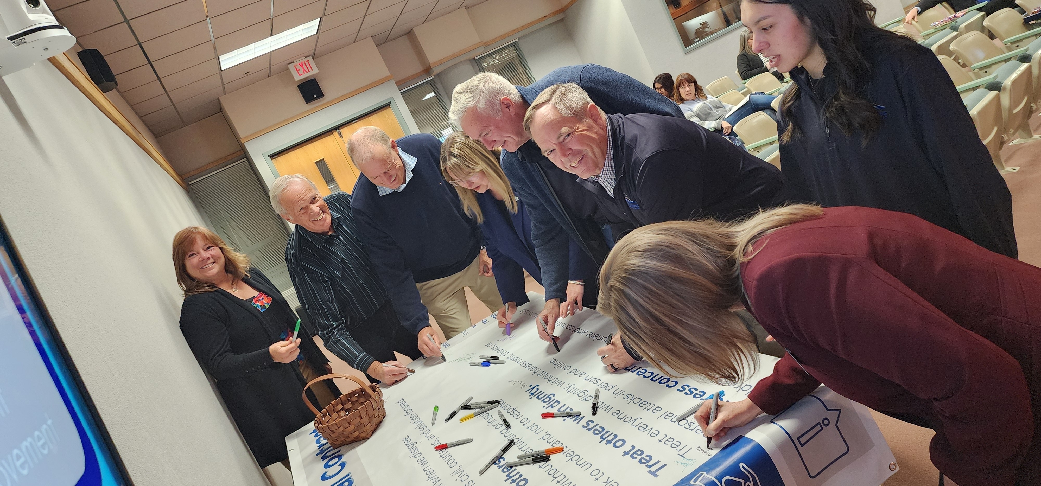 School Board Members signing banner