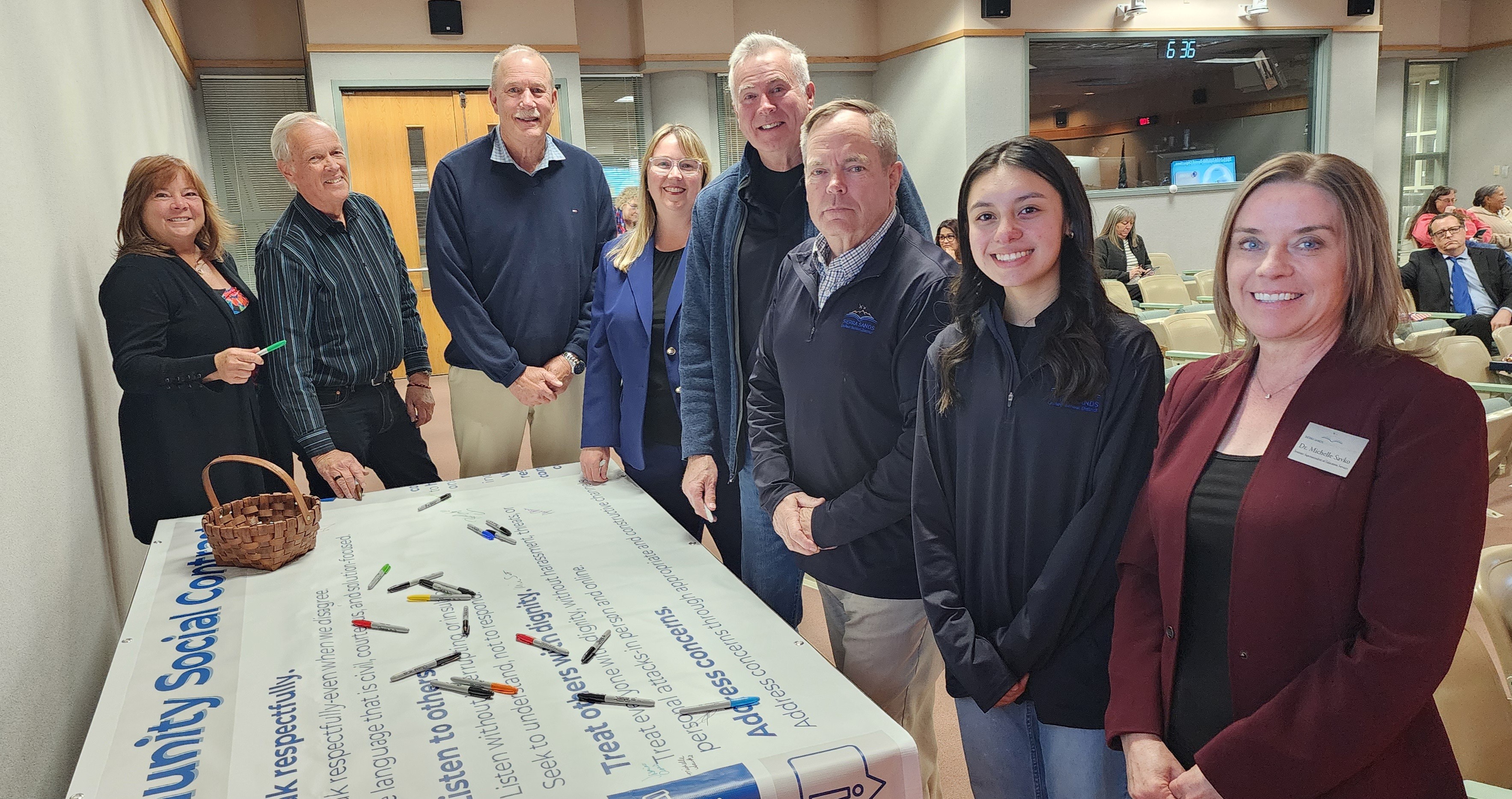 People gathered around a large banner