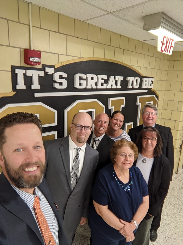 Seven Members of the Board of Education Group Photo (Selfie in-front of a sign reading "It's Great to be Gold")