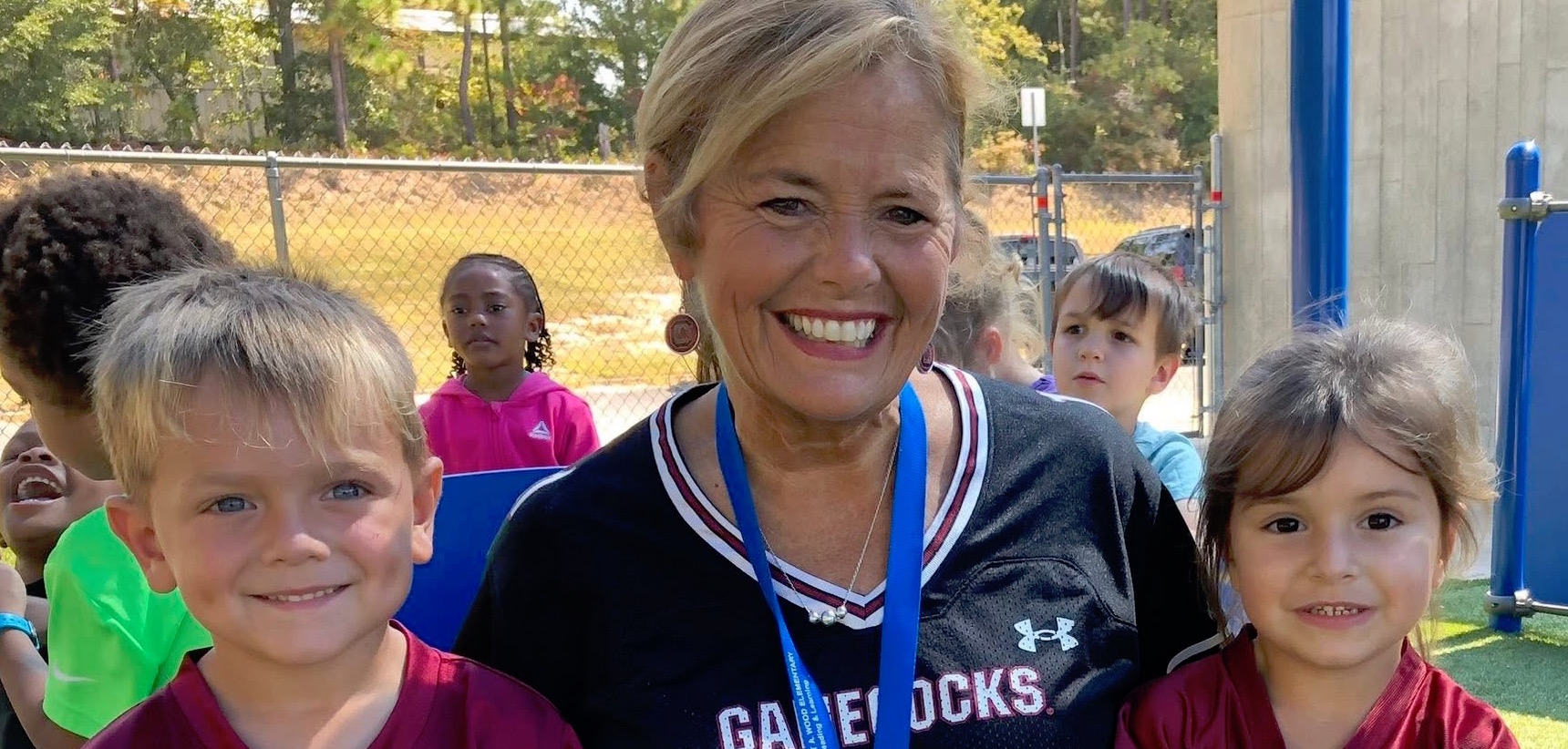 Teacher with 2 students in Gamecock jerseys
