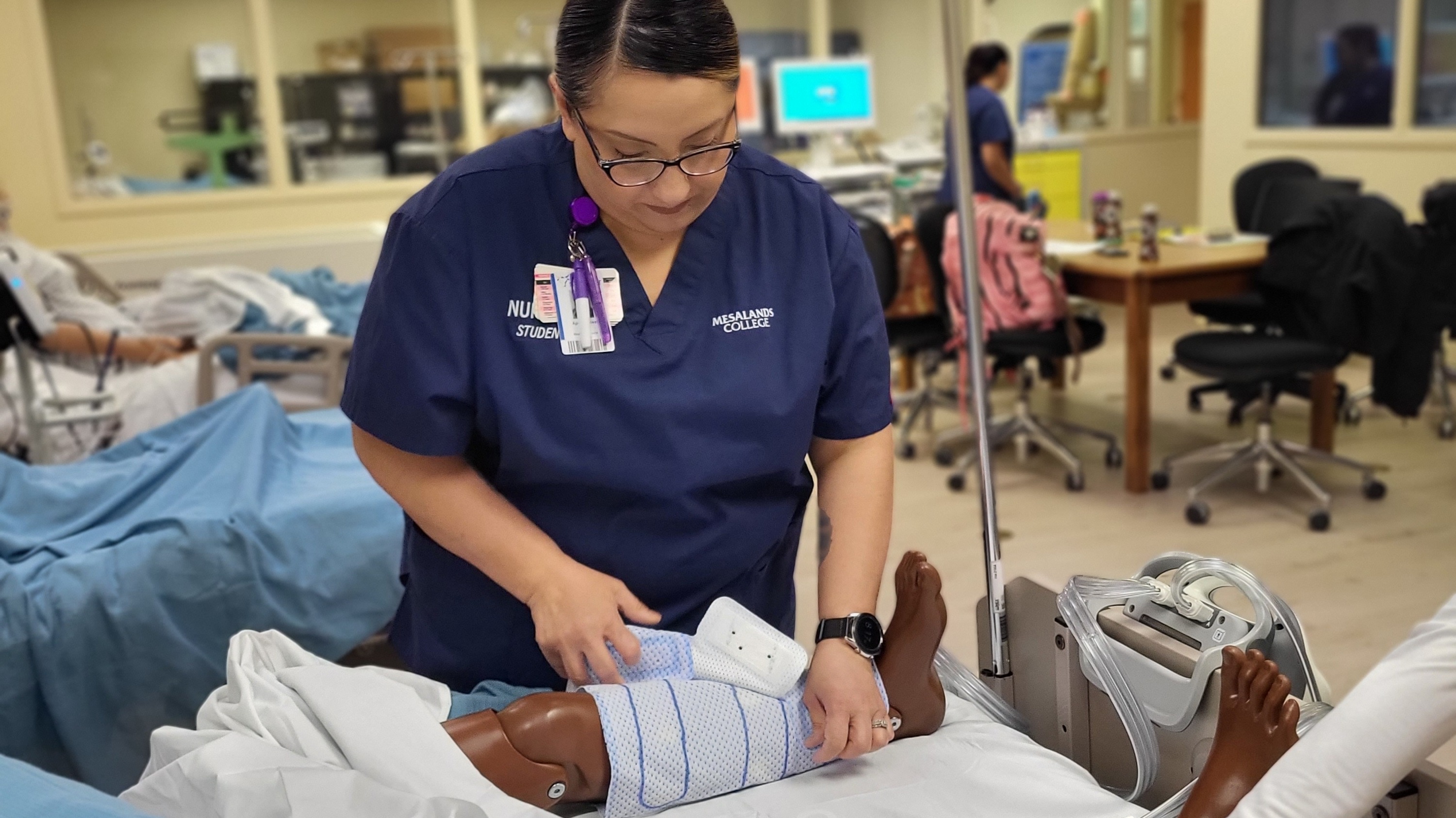 A nursing student practicing on a mannequin in the sim lab