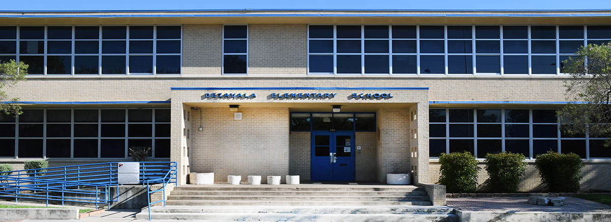 Front view of Lorenzo De Zevala Elementary school with blue wording of school name and bright tan bricks.