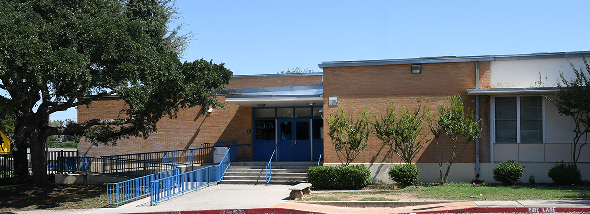 Front view of Kate Schenck Elementary school with blue hand railings leading up ramp and stair entrance.