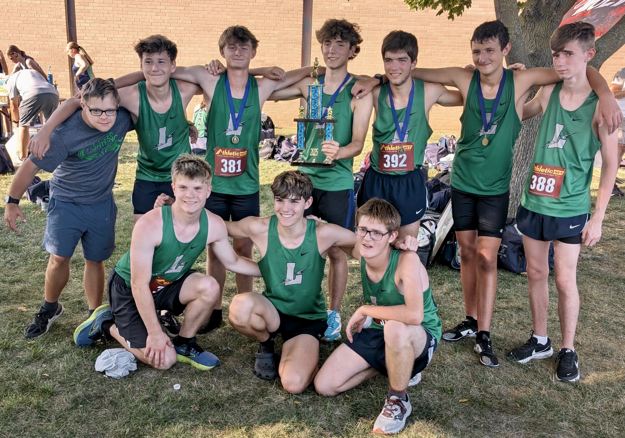 Lapeer boys cross country team with a trophy after winning a meet