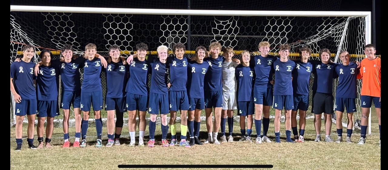 Varsity soccer players in Coach Bud shirts