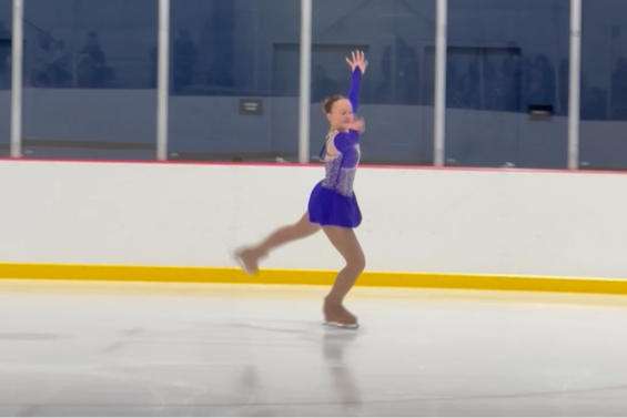 girl in blue dance costume figure skating on the ice