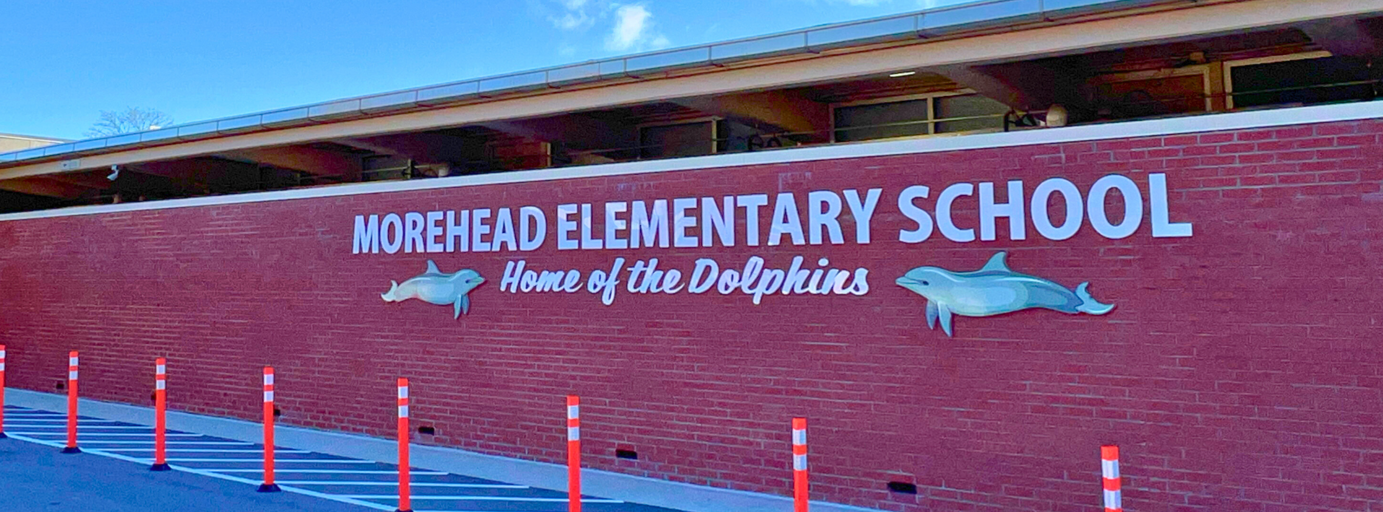 Brick wall with Morehead Elementary School Home of the Dolphins sign.