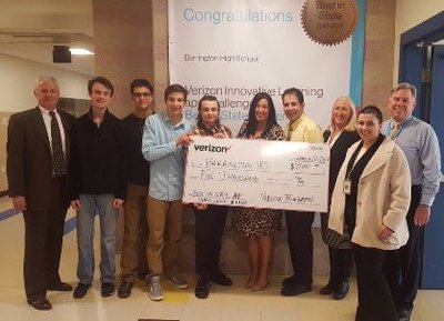 A photo of students and teachers holding a giant check from Verizon