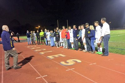 A photo of students and parents on the sidelines at a football game