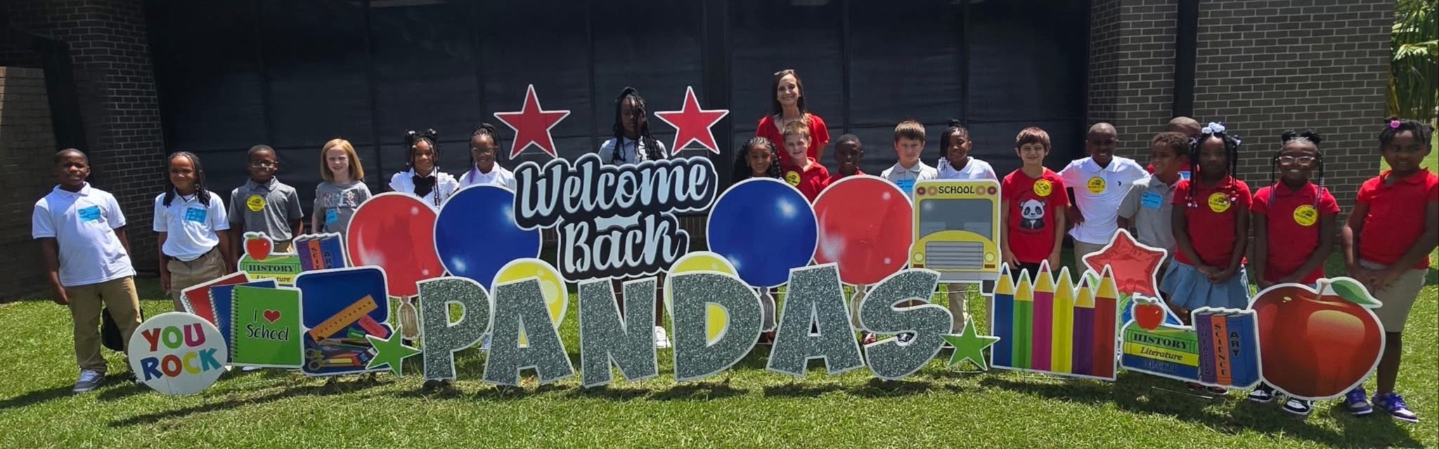 Students in front of school with sign
