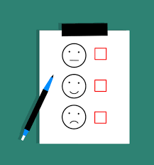 A graphic of a piece of paper on a clipboard, the piece of paper has 3 facial expressions on it with check boxes beside them