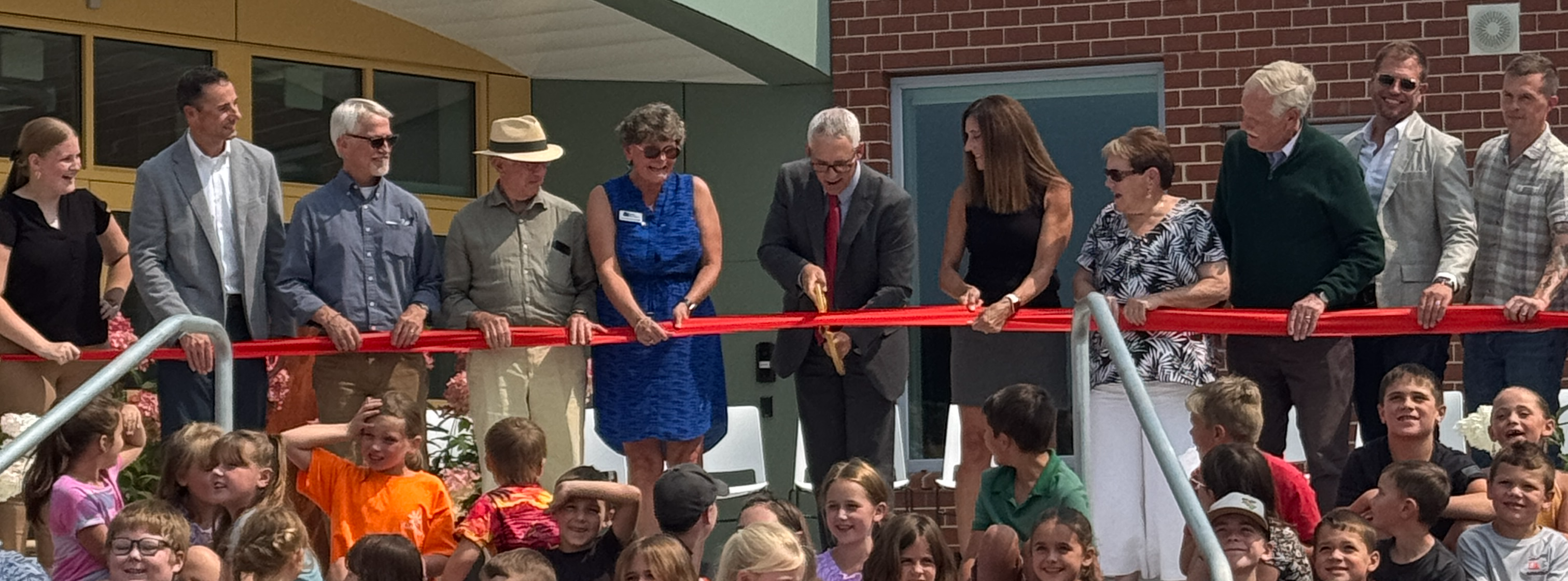 Ribbon being cut on the steps of the Margaret Chase Smith Community School