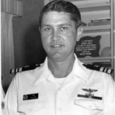 A black and white photo of a man in military uniform, standing proudly with a serious expression.