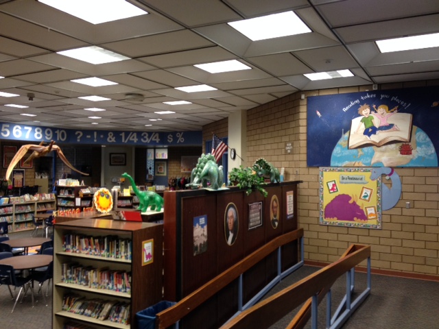 A library interior featuring shelves filled with books and colorful toys for children.