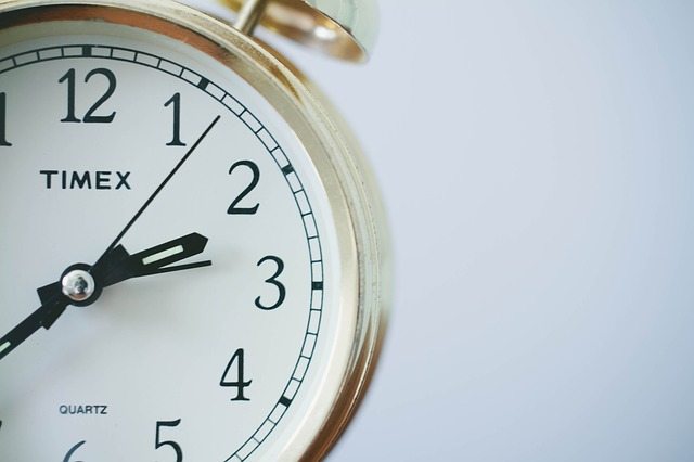 A close-up view of a Timex alarm clock displaying the time and alarm settings on its digital screen.