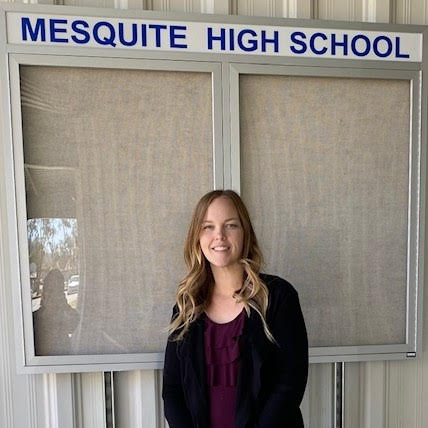 1. A woman stands proudly in front of a sign for Mesquite High School, showcasing the school's name and logo. 2. A woman poses in front of the Mesquite High School sign, highlighting the school's identity and welcoming atmosphere. 3. A woman stands beside the Mesquite High School sign, emphasizing the school's name and its significance to the community.