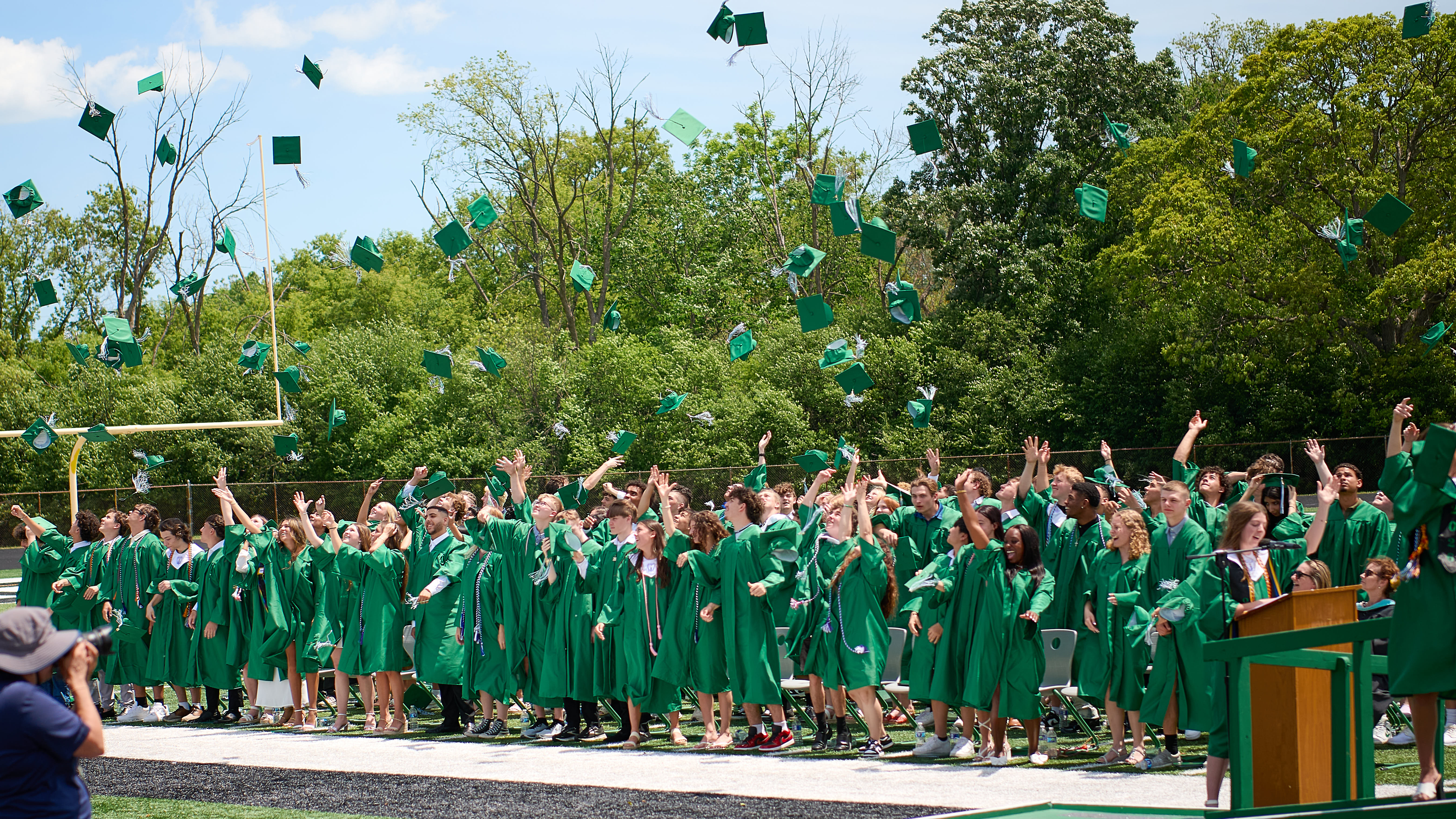 Students in gowns tossing their caps
