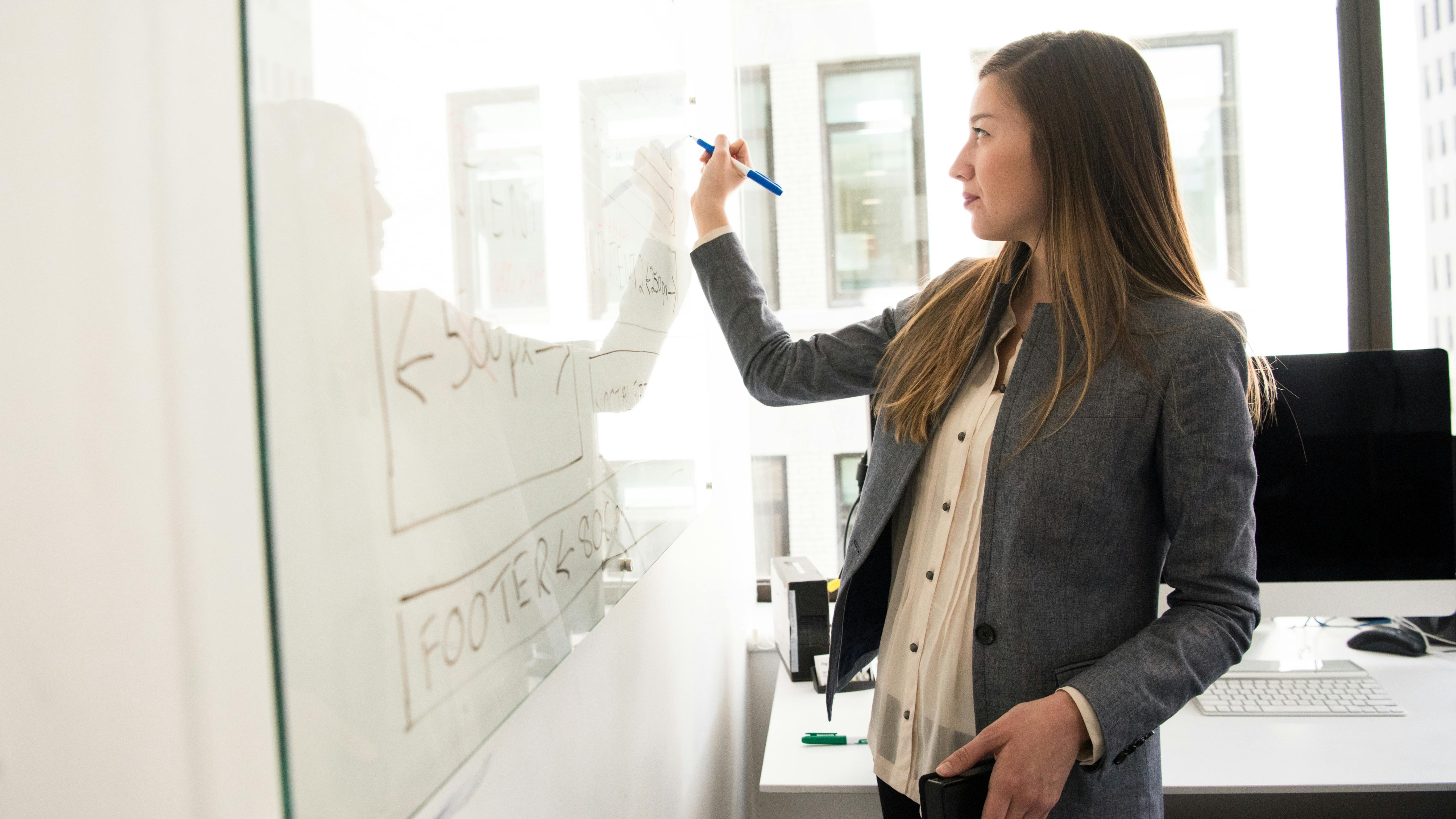 Teacher writing on a white board