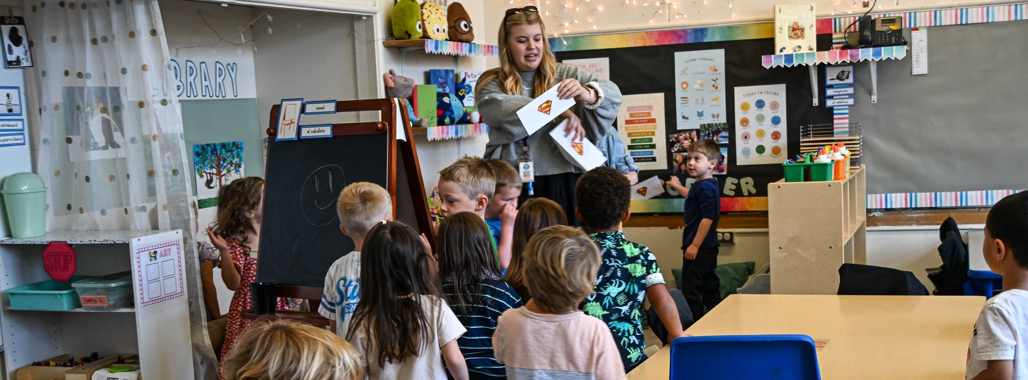 Preschool classroom with kids surrounding teacher