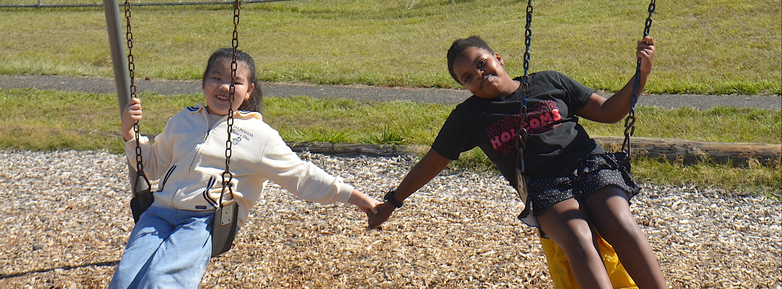 Kids on swing holding hands