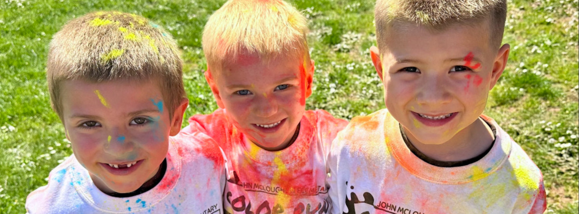 Three children with shirts with paint on it