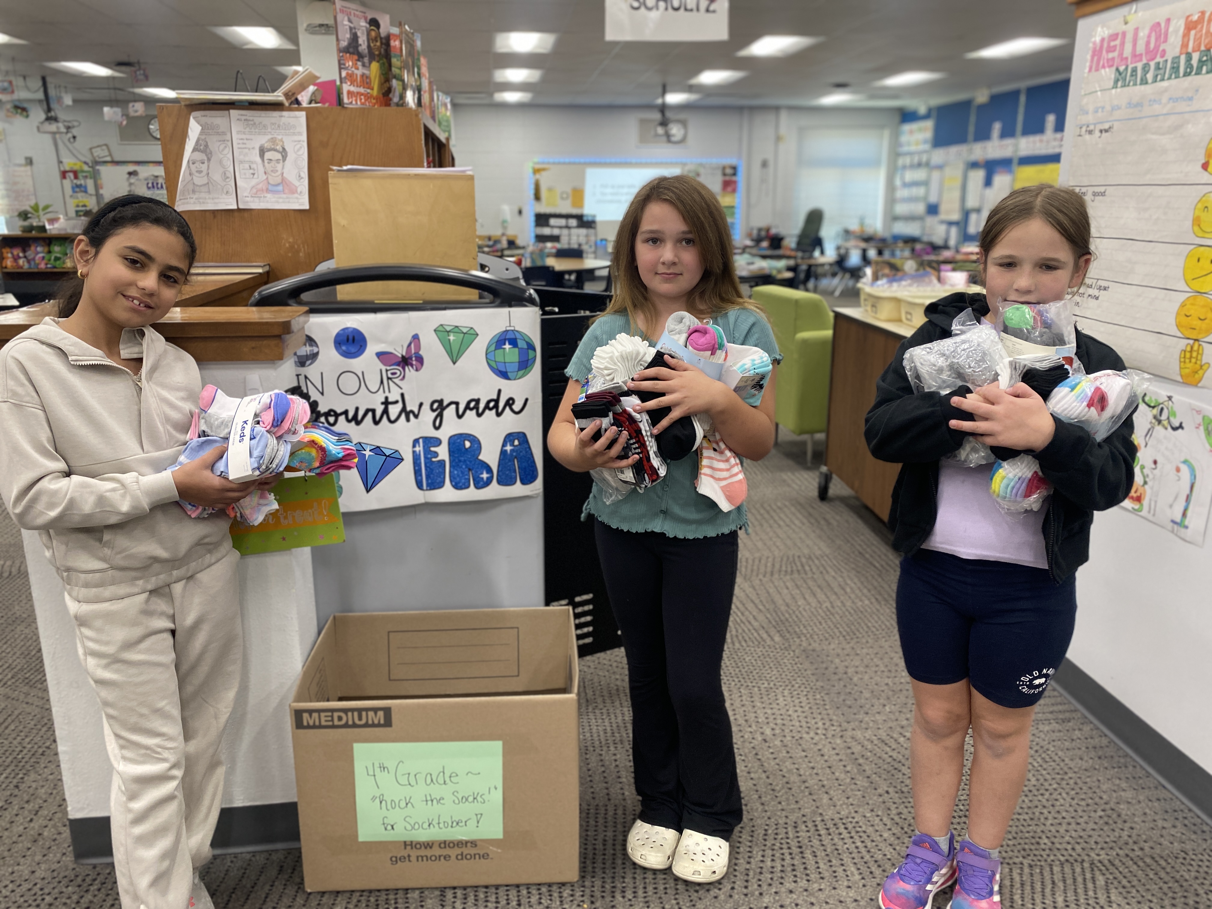 girls with sock donations box