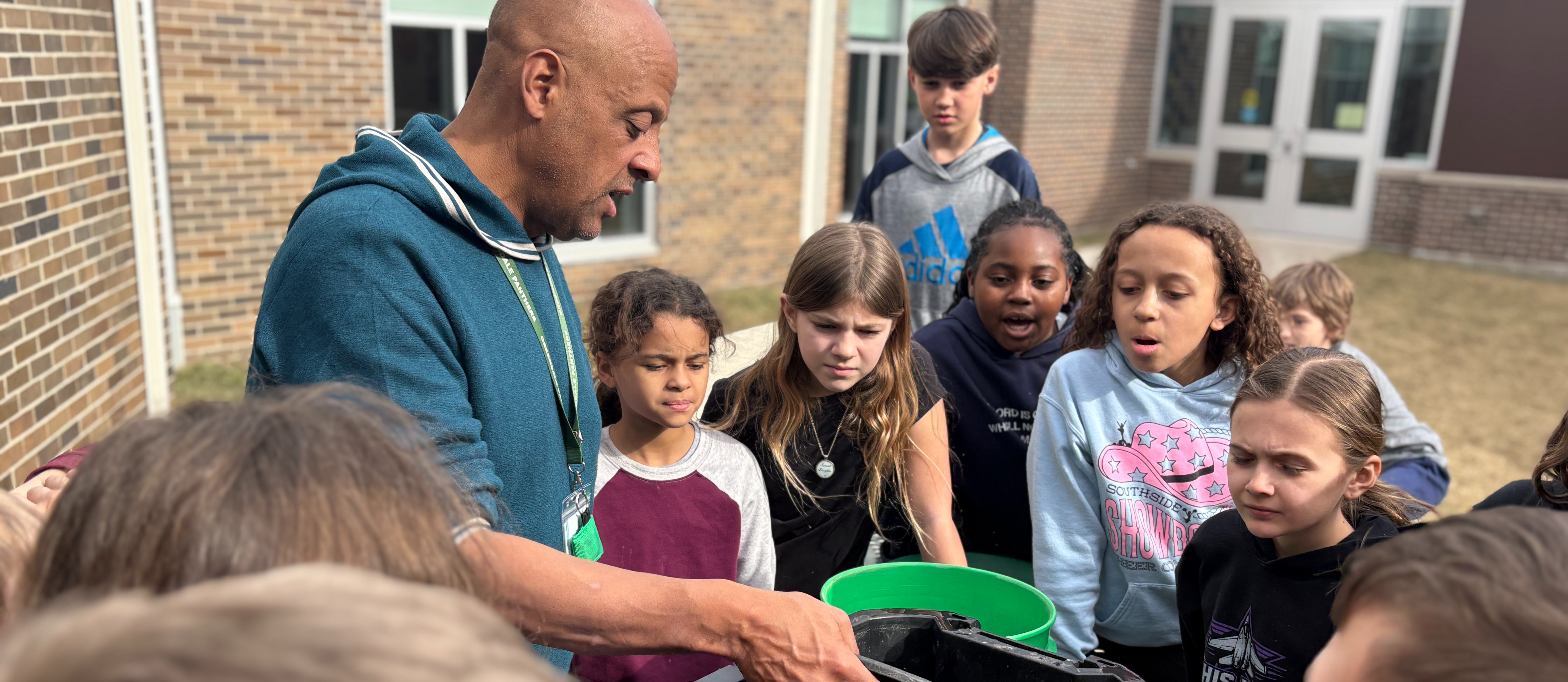 Principal showing students how to pan for gold